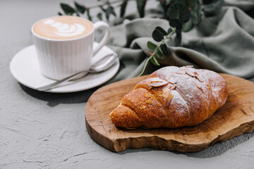 Almond Croissant on plate with cup of coffee