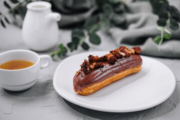 Eclair with Chocolate Cream and Hazelnuts and tea
