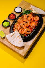 Fried large shrimp with onions and peppers in a frying pan