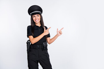 Photo of pretty charming young police lady wear black uniform cap pointing looking empty space...