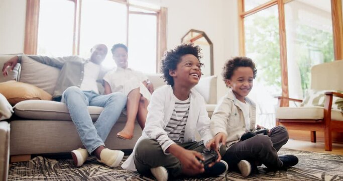 Happy black family and boys playing video games on living room floor for fun holiday weekend at home. Father and mother smile watching children play on console for relax and entertainment at house
