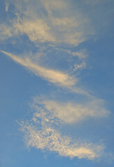 A blue cloudy sky with many small clouds blocking the sun