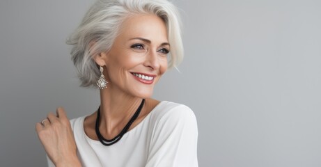  A blonde older woman with grey hair smiling - Powered by Adobe