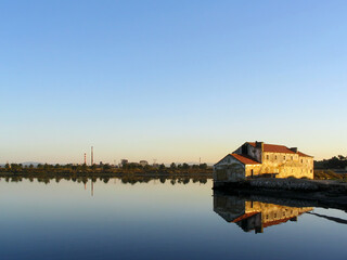 Old ruined Tide Mill and water mirror at Seixal Bay by sunset. One of the surviving Tide-Mills in Europe.
