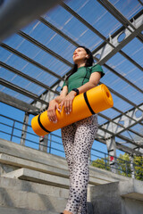 Fototapeta premium Fit and Fabulous: Young Woman Unfolding Mat in Stadium