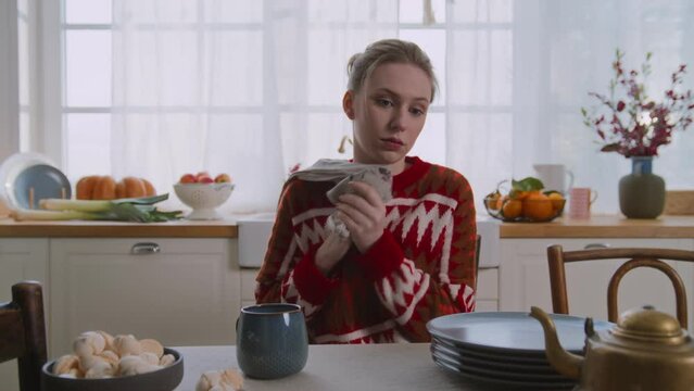 overworked young woman sit down at table to have break and breath out after housework and cooking. tired housewife needs timeout to recovery after kitchen fussing