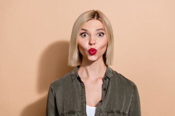 Photo of stunned lady expressing excitement lips pouted like air kiss wear khaki shirt isolated...