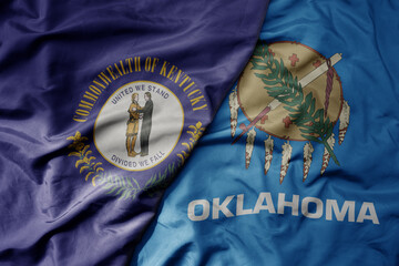 big waving colorful national flag of oklahoma state and flag of kentucky state .