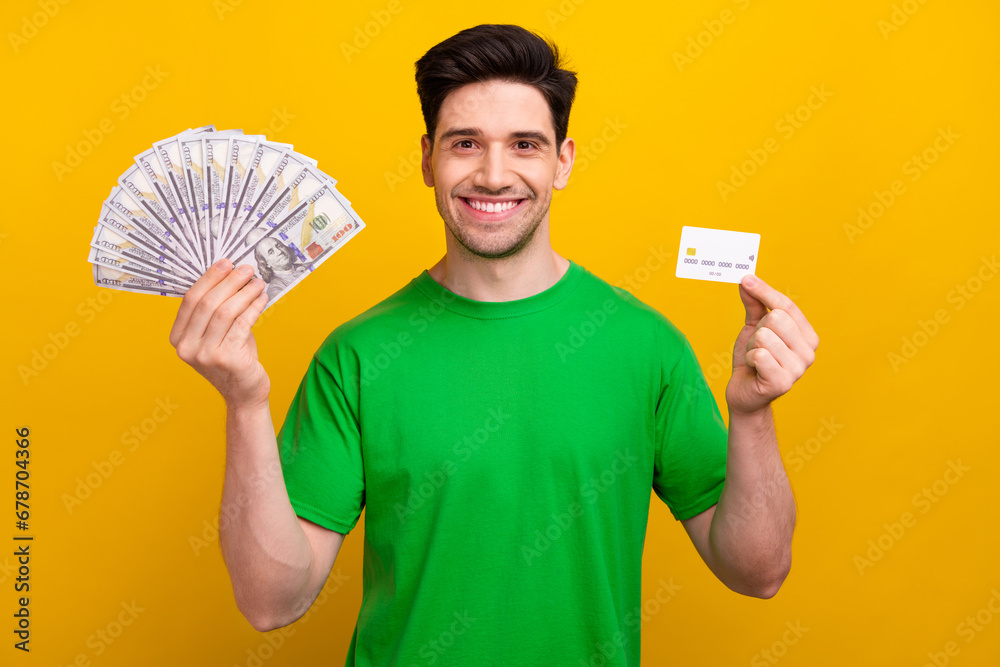 Canvas Prints Photo portrait of nice young brunet male hold credit card money fan wear trendy green garment isolated on yellow color background