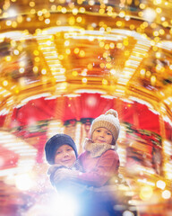 Cute girl and boy enjoying the holidays at Christmas. Happy siblings play in the illuminated xmas...