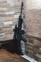 Civilian weapon for home defense. An ar 15 rifle with an optical sight near the wall in the room.