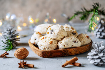 Italian traditional Christmas sweets Cavallucci over grey background with xmas decoration, evergreen tree branches and spices