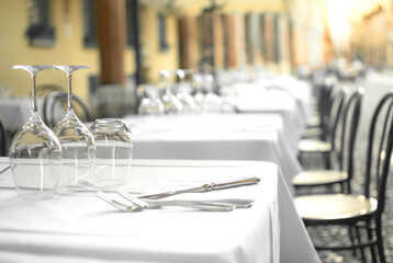 Elegant Restaurant tables in row terrace and rustic grey stone street background
