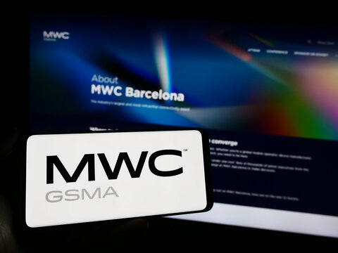 Stuttgart, Germany - 11-09-2023: Person holding smartphone with logo of annual mobile communications trade show MWC Barcelona in front of website. Focus on phone display.