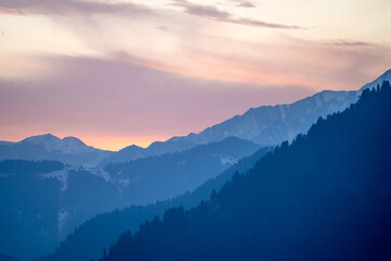 Pink blue hues of himalaya mountains fading off into fog showing the serene view from Manali Kullu...