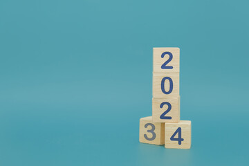 Vertical woodblocks cubes square with number 2023 change to 2024 on blue background, New year 2024 concept.