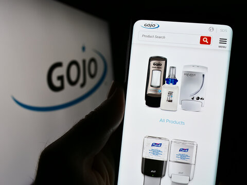 Stuttgart, Germany - 11-10-2023: Person holding smartphone with webpage of US consumer goods company Gojo Industries Inc. in front of logo. Focus on center of phone display.
