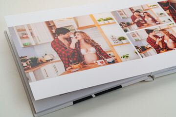 Fototapeta na wymiar The pages of a photo book with color photos of a pregnant blonde and a man. 