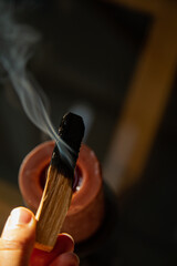 Burning and smoking palo santo on a wooden plate