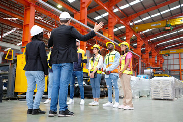 Engineers and employees stand in a meeting to plan work in an industrial factory.