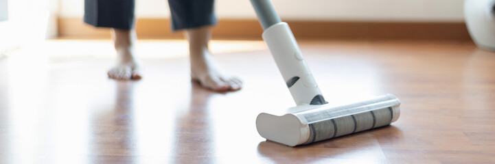 Woman vacuuming the floor of her living room, Big cleaning in the house, Removes germs and dirt and deep stains, Housewife cleaning, Keeping her home clean, Domestic hygiene.