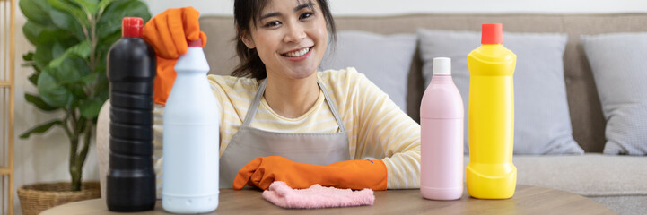 Beautiful Asian housewife wearing apron and cleaning gloves prepares to clean her house, Housework, Daily routine, Big cleaning, Abrasive liquid removes deep stains, Clean up on weekends.
