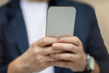 Young caucasian man student in casual typing on mobile phone, chatting in social networks