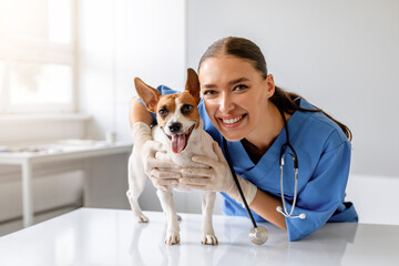 Female vet with happy dog - obrazy, fototapety, plakaty