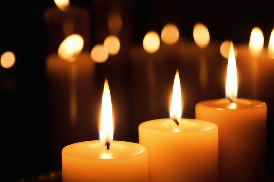 Burning candles on dark background, close-up