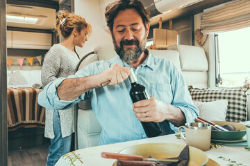 Adult traveler couple enjoy lunch time inside a camper van. Nomadic alternative lifestyle. Travel...