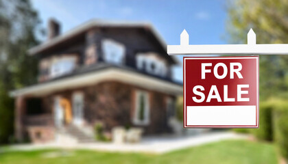 For sale real estate sign with blurred house in background - obrazy, fototapety, plakaty
