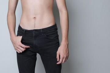 Naked torso of young guy from the front in jeans
