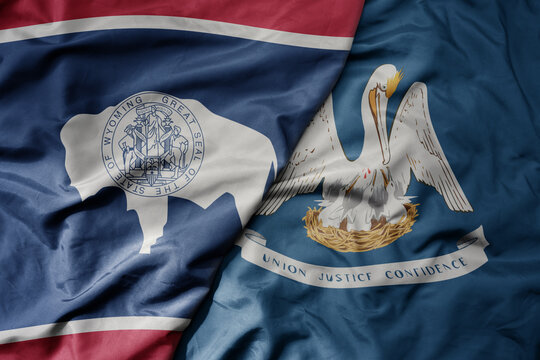 big waving colorful national flag of louisiana state and flag of wyoming state .