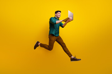 Fototapeta na wymiar Photo of cheerful attractive man dressed trendy clothes using empty space writing typing text isolated on yellow color background