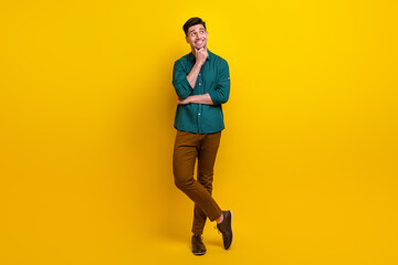 Fototapeta na wymiar Full length photo of minded nice man wear trendy clothes look up empty space interesting offer banner isolated on yellow color background