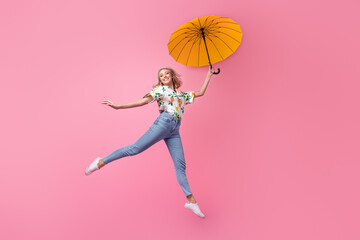 Full length body photo of jumping high trampoline up funny young girl good mood bring umbrella...
