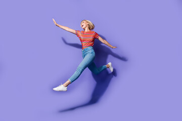 Fototapeta na wymiar Full body photo of freedom celebrating ukrainian lady jumping air flying hands wings in casual look isolated over violet color background