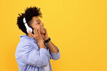Happy black man enjoying music on headphones