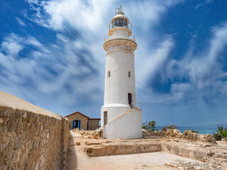 Island of Cyprus. City of Paphos. White lighthouse on seashore. Sights of Cyprus. Paphos in sunny weather. Lighthouse on territory of archaeological park. Tour of Paphos. Travel to Cyprus
