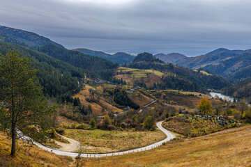 Fototapeta premium Mountain village in Serbia in bright autumn colors with Cemetery on the front