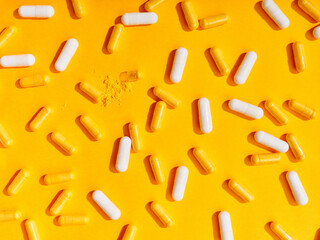 Flat lay pattern various food supplement pills on yellow background