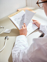 Anonymous medical professional going through the patient's paperwork in a hospital