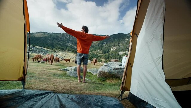 Tourist man getting out of tent in camping at vacation travel adventure 