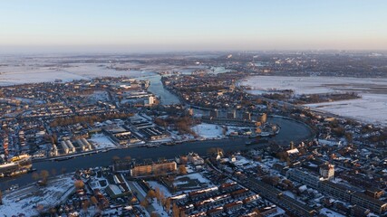Aerial view of a winding river in a city covered in snow