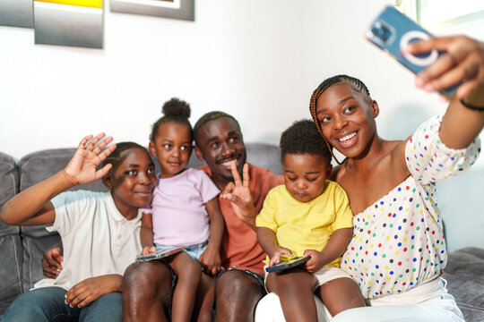 Cheerful family of six enjoying a moment together with a selfie at a cozy home setting.