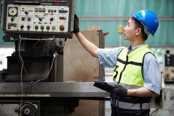 factory worker or technician holding tablet checking and control lathe machine in factory