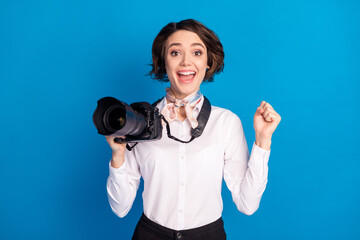 Photo of delighted impressed lady open mouth fist up celebrate achieve isolated on blue color background