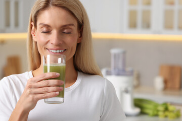 Woman drinking fresh celery juice in kitchen. Space for text