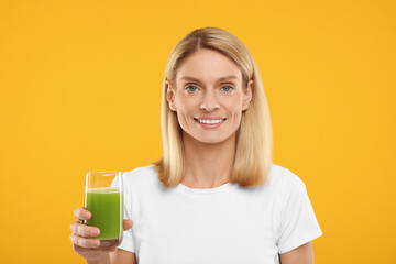Happy woman with glass of fresh celery juice on orange background