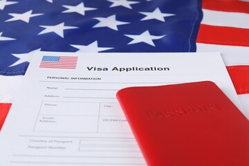 Fototapeta na wymiar Immigration to USA. Visa application form and passport on flag, closeup